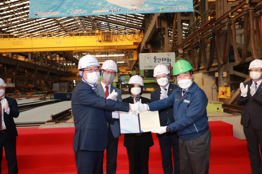 19일 오후 울산 현대미포조선에서 열린 ICT 융합 전기추진 스마트선박 강재 절단식에서 송철호(맨왼쪽) 울산시장과 신현대 현대미포조선 사장이 선급증서 전달식을 하며 악수하고 있다. 울산시 제공